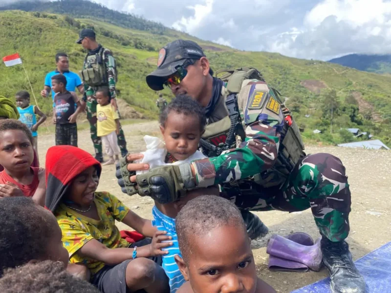 Prajurit Satgas Yonif 112/DJ membagikan pakaian layak pakai kepada warga Kampung Kalome, Papua Tengah. (Foto:Dok/Kodam.IM)