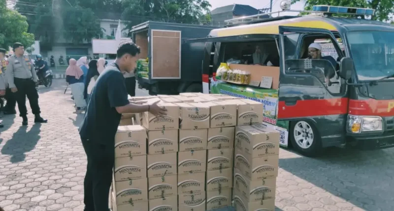 Petugas Polresta Banda Aceh dan Bulog menata paket beras dan minyak goreng di halaman Masjid Baitussalihin. (Foto:Dok/Polresta)