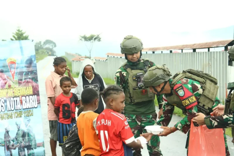 Personel Satgas Yonif 112/DJ membagikan makanan kepada warga dalam kegiatan rutin Jumat Berkah di Puncak Jaya. (Foto:Arsip Kodam IM)