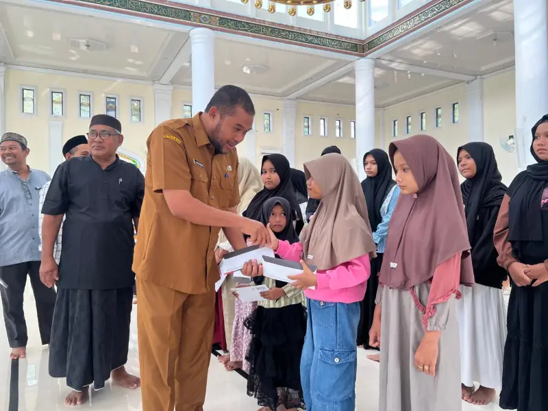 Camat Lhoknga, Zayadinur, SSTP menyerahkan santunan anak yatim program CSR Solusi Bangun Andalas di Mesjid Kemukiman Kueh yang disaksikan oleh tokoh masyarakat, 10 Maret 2026. (Foto:Arsip SBA)