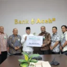Direktur Utama Bank Aceh Syariah menyerahkan zakat karyawan kepada Baitul Mal Aceh. (Foto:Arsip Bank Aceh)