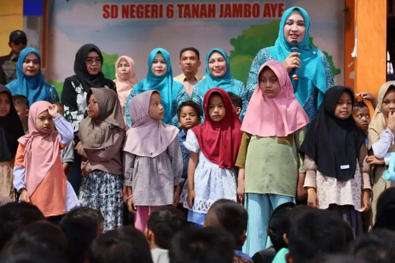 Marlina Muzakir (Kak Na) membagikan seragam sekolah kepada siswa korban banjir Aceh Utara. (Foto:Dok/Ist)
