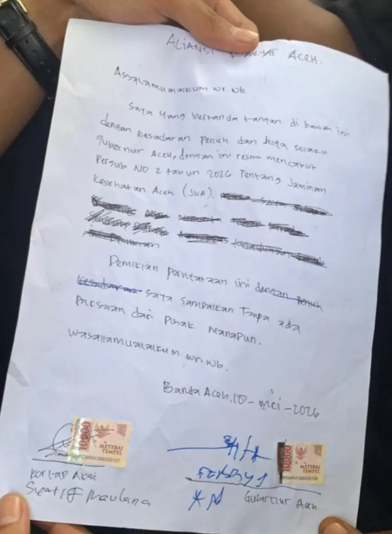 Surat komitmen pencabutan Pergub JKA diperlihatkan kepada massa aksi mahasiswa di halaman kantor gubernur Aceh. (Foto:Dok/Ist)