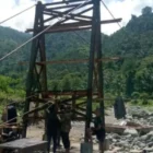 Pembukaan bekisting pondasi jembatan gantung Desa Jambur Mamang. (Foto:Dok/kodim 0108)