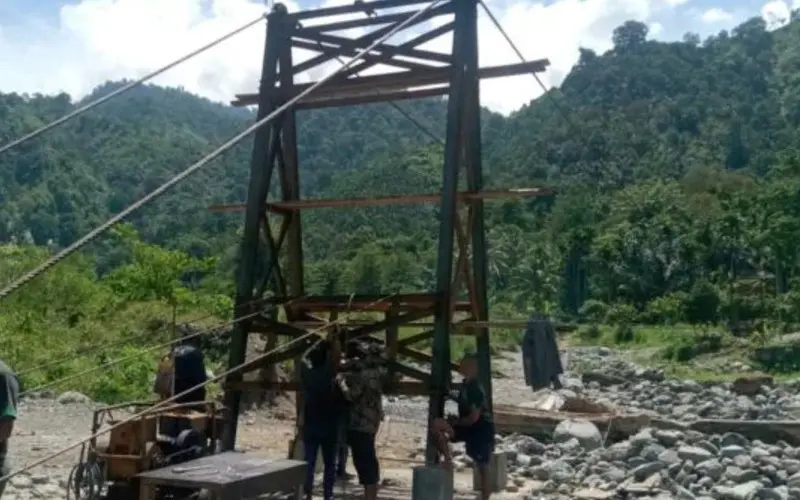 Pembukaan bekisting pondasi jembatan gantung Desa Jambur Mamang. (Foto:Dok/kodim 0108)