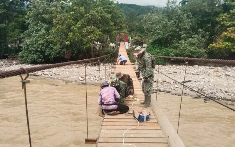 Personel TNI dan warga mengecat Jembatan Gantung Perintis di Ketambe. (Foto:Dok/Kodam IM)