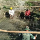 Warga dan Babinsa gotong royong bangun pondasi jembatan gantung. (Foto:Dok/Ist)