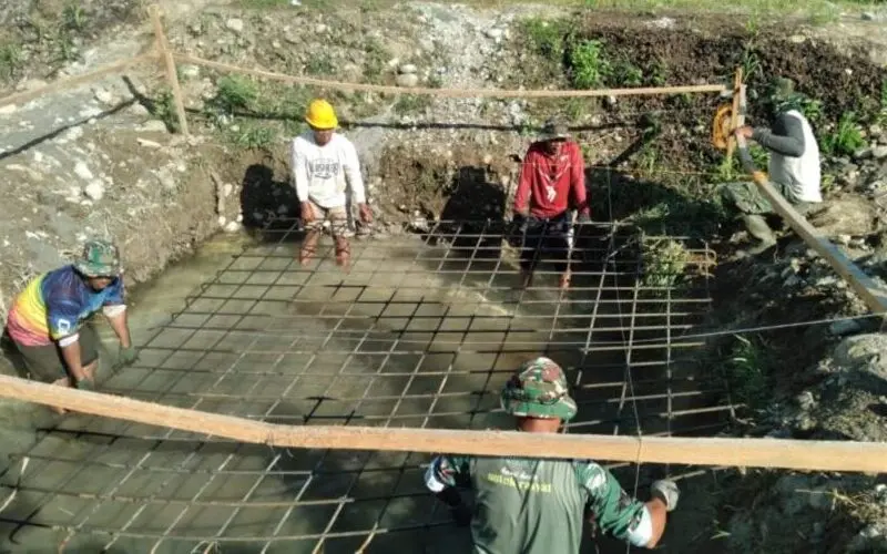 Warga dan Babinsa gotong royong bangun pondasi jembatan gantung. (Foto:Dok/Ist)
