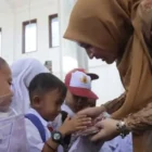 Kak Na menyerahkan seragam kepada siswa sekolah darurat Aceh Tengah. (Foto:Dok)