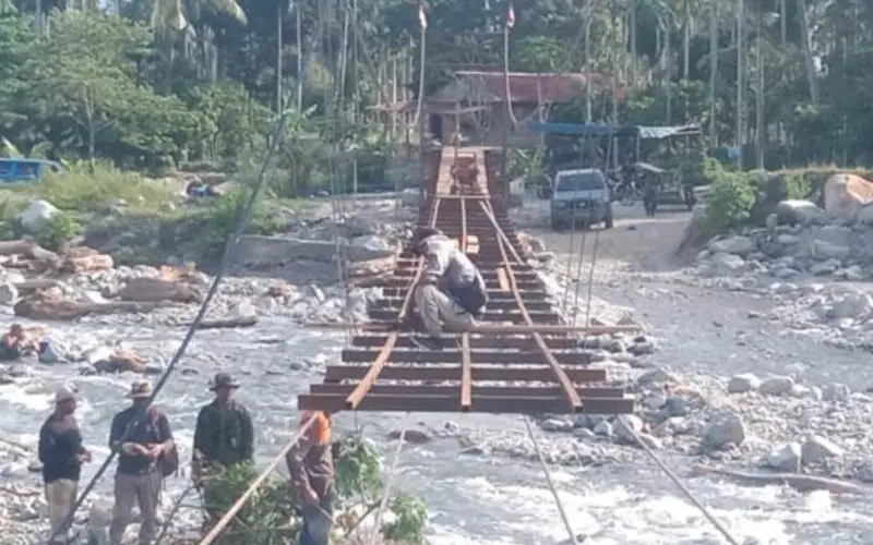 Pemasangan papan lantai Jembatan Gantung Perintis Aceh Tenggara. (Foto:Dok/Kodim 0108)