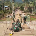Babinsa dan warga mengecat Jembatan Gantung Perintis di Ketambe. (Foto:Dok/Kodim 0108)