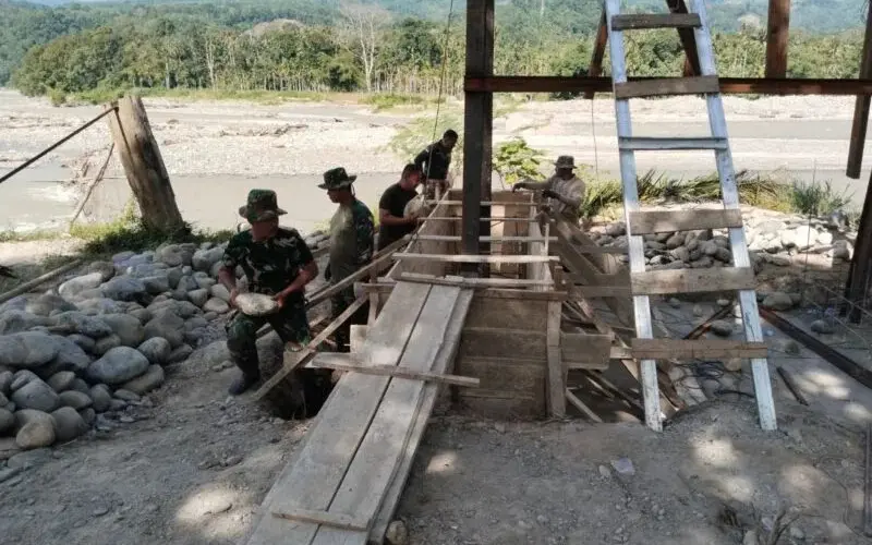Babinsa dan warga membangun Jembatan Gantung Perintis Lawe Ger Ger. (Foto:Dok/Kodam IM)