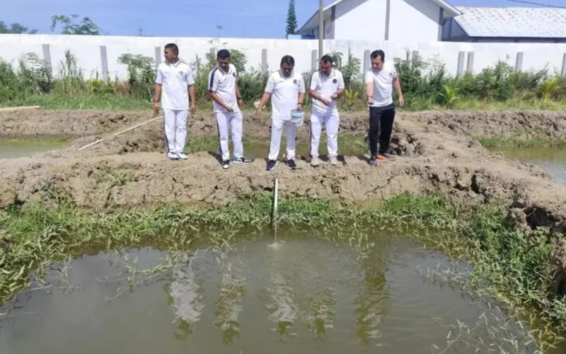Akhmad Heru Setiawan Kepala Lapas Kelas IIA Banda Aceh sedang melakukan penebaran 4.000 benih ikan nila di kolam budidaya Lapas Banda Aceh. (Foto:Dok/Lapas Banda Aceh)